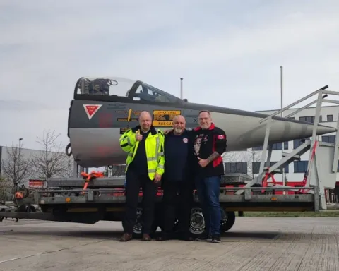 Team poses in front of the Starfighter cockpit