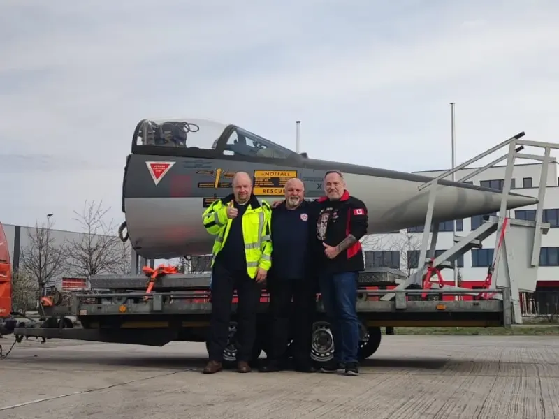 Team poses in front of the Starfighter cockpit